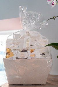 Godiva chocolate gift basket in a white woven container, wrapped in clear cellophane.