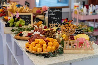 Charcuterie board with cheese, meats, nuts, fruits, and bread on a counter.