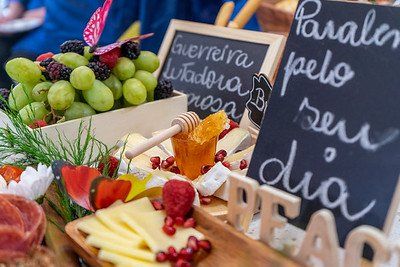 A food spread with grapes, cheese, and handwritten signs celebrating a special occasion.