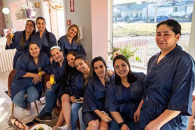 Group of women in blue robes smiling inside a brightly lit room.