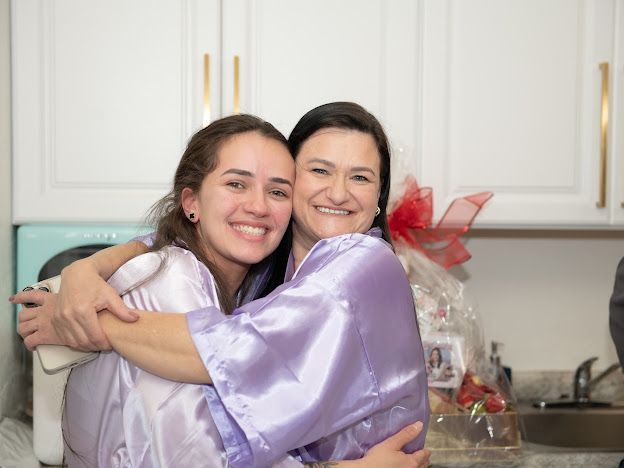 Two women are hugging each other in a kitchen.