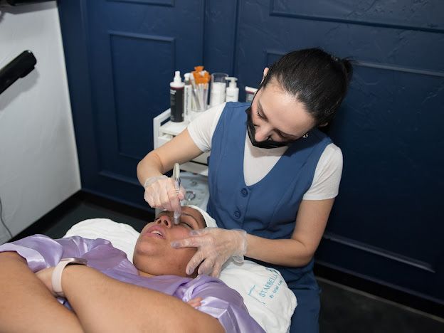 A woman is giving a woman a facial treatment in a beauty salon.