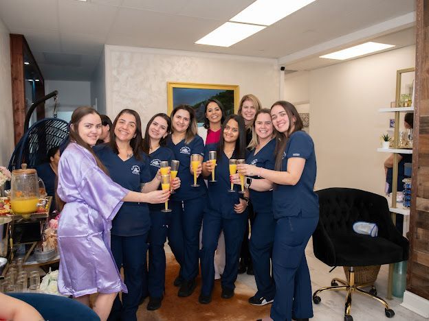 A group of women are standing in a room holding champagne glasses.