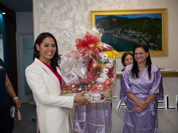 A woman in a white suit is holding a basket of flowers.