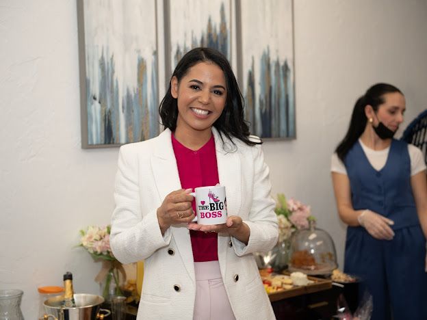 A woman in a white suit is holding a basket of flowers.