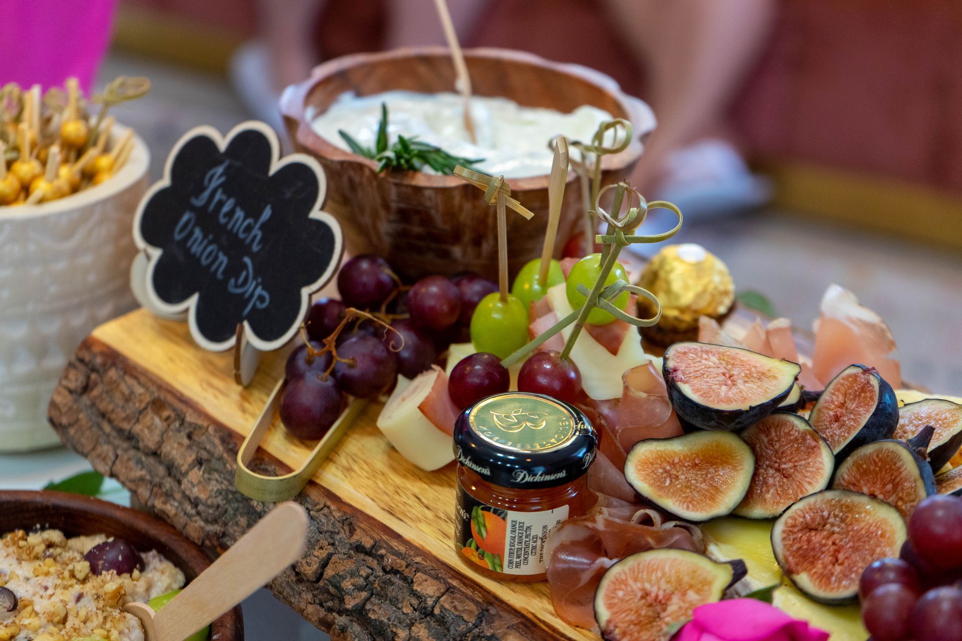 Charcuterie board with grapes, figs, cheese, prosciutto, and French onion dip.