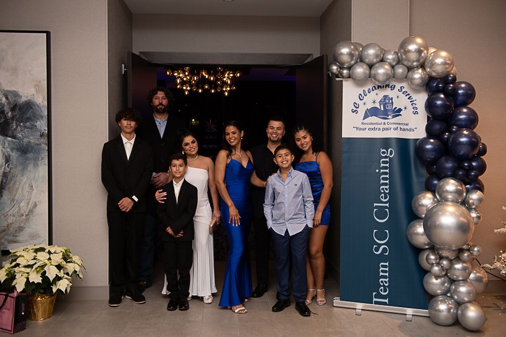 A family poses in front of a banner for