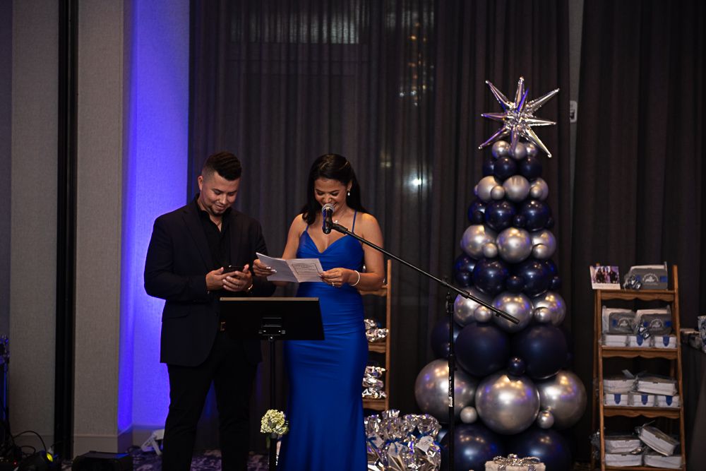 Man and woman at event, woman reading, balloons and decorations.