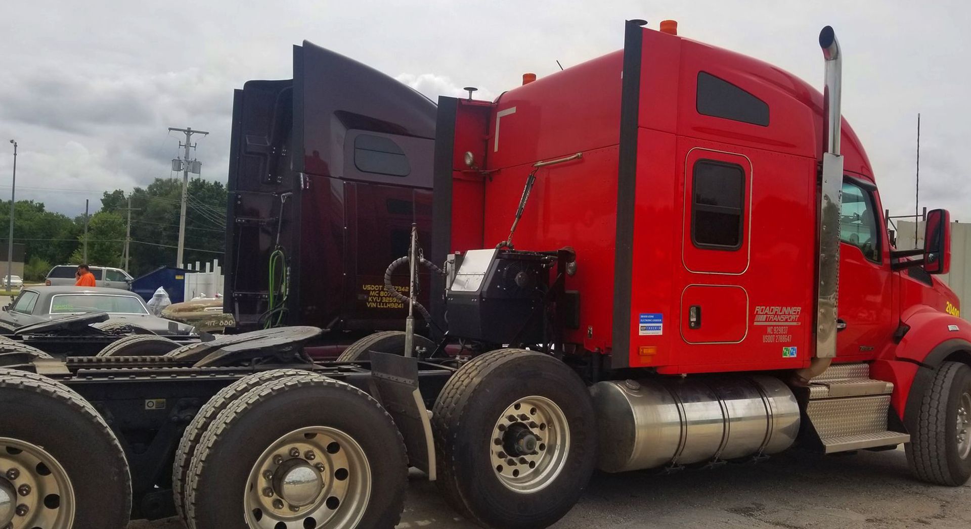 Red semi-truck parked outdoors, showing the cab and rear chassis on a cloudy day.