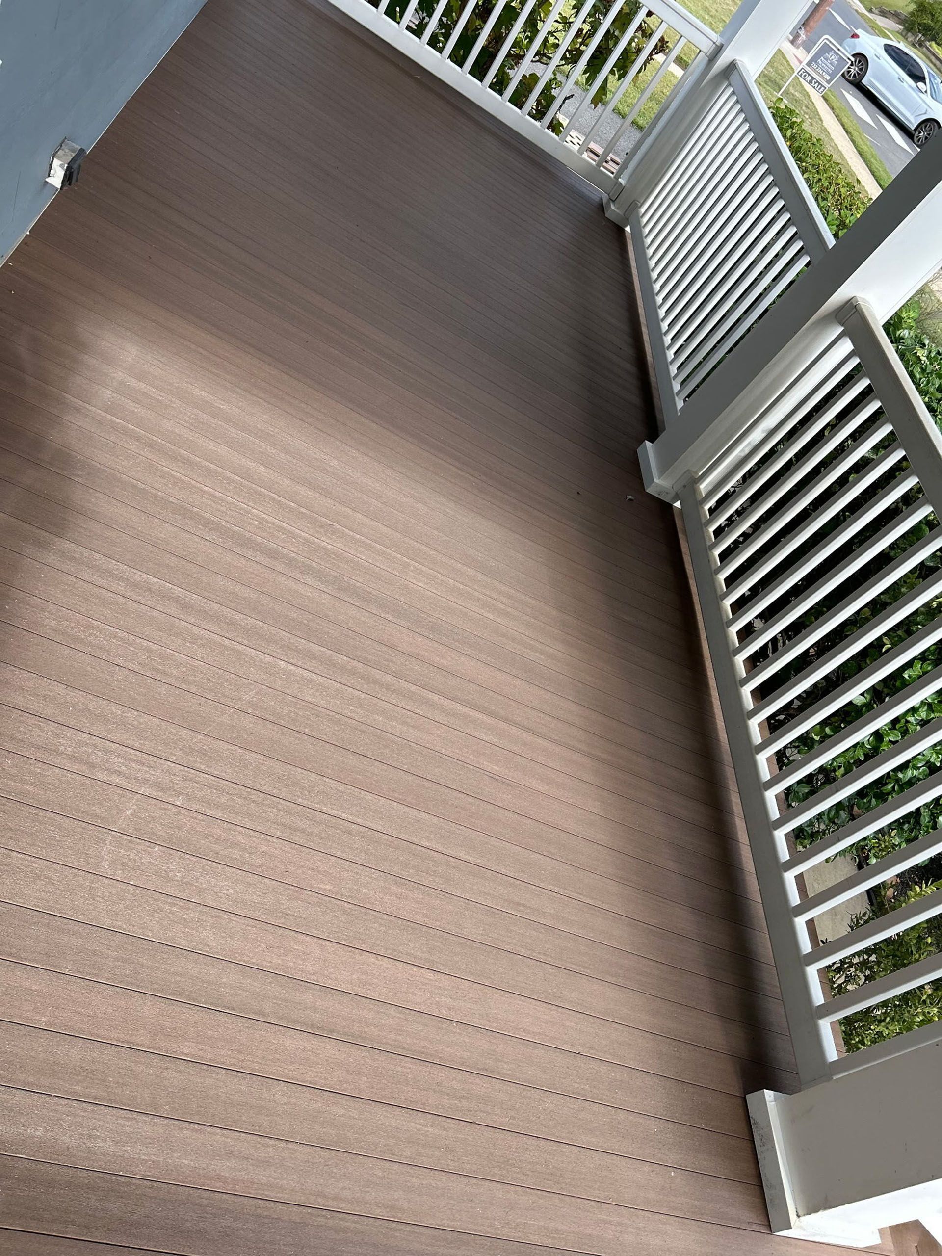 Brown composite deck with white railings.