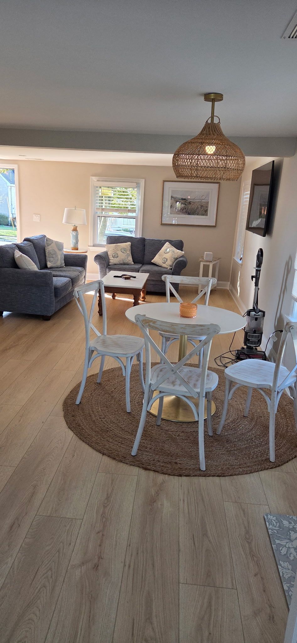 Living room with a dining area, featuring a table with chairs and couches.