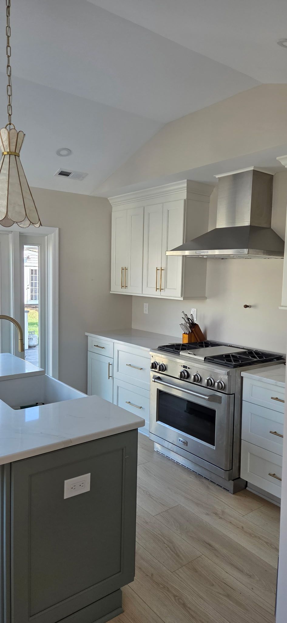 Kitchen with white cabinets, stainless steel appliances, and gray island.