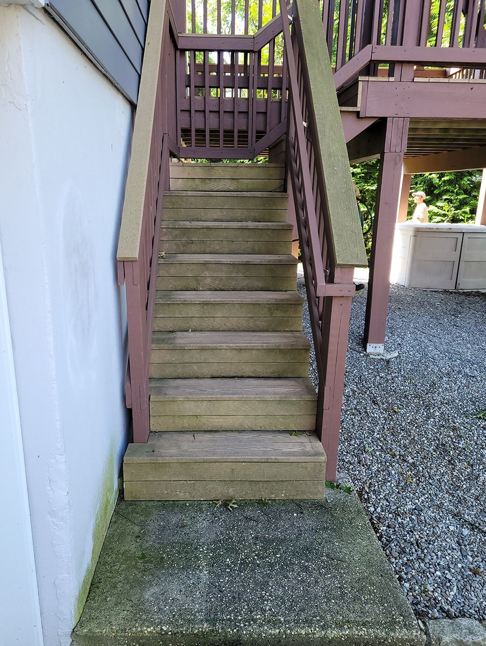 A set of stairs leading up to a deck with a wooden railing.