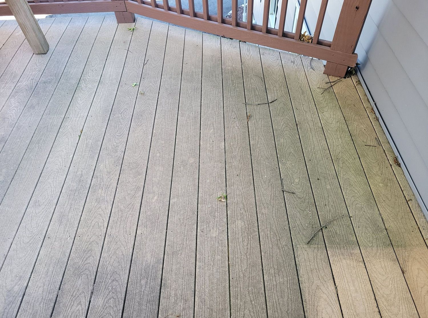 A wooden deck with a railing and a chair on it.