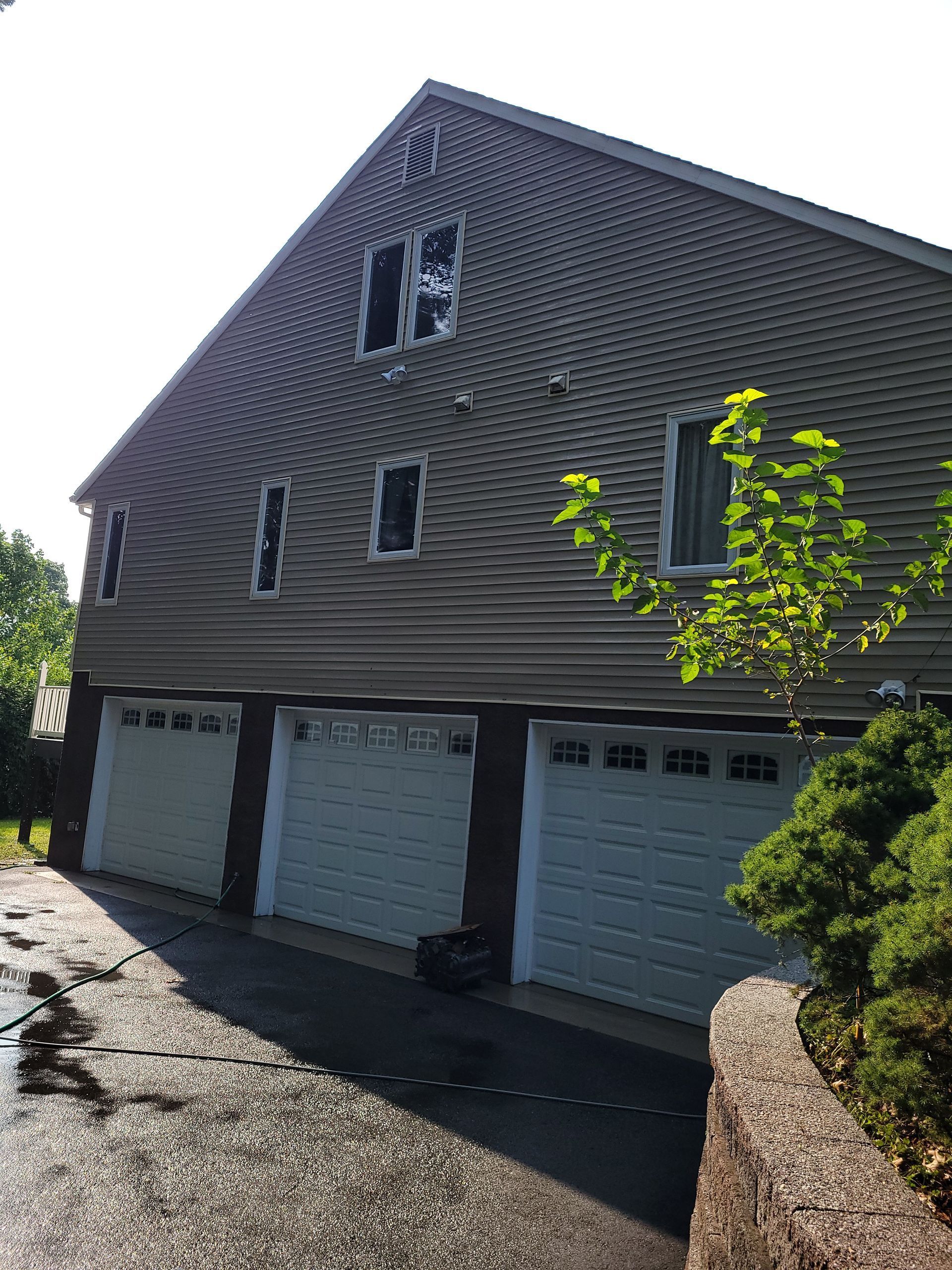 A large house with three garage doors and a driveway