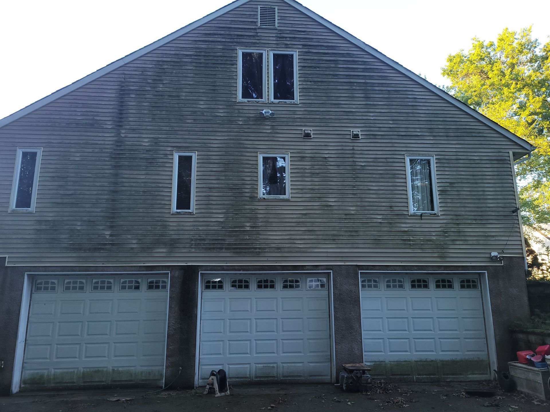 A house with three garage doors and two windows