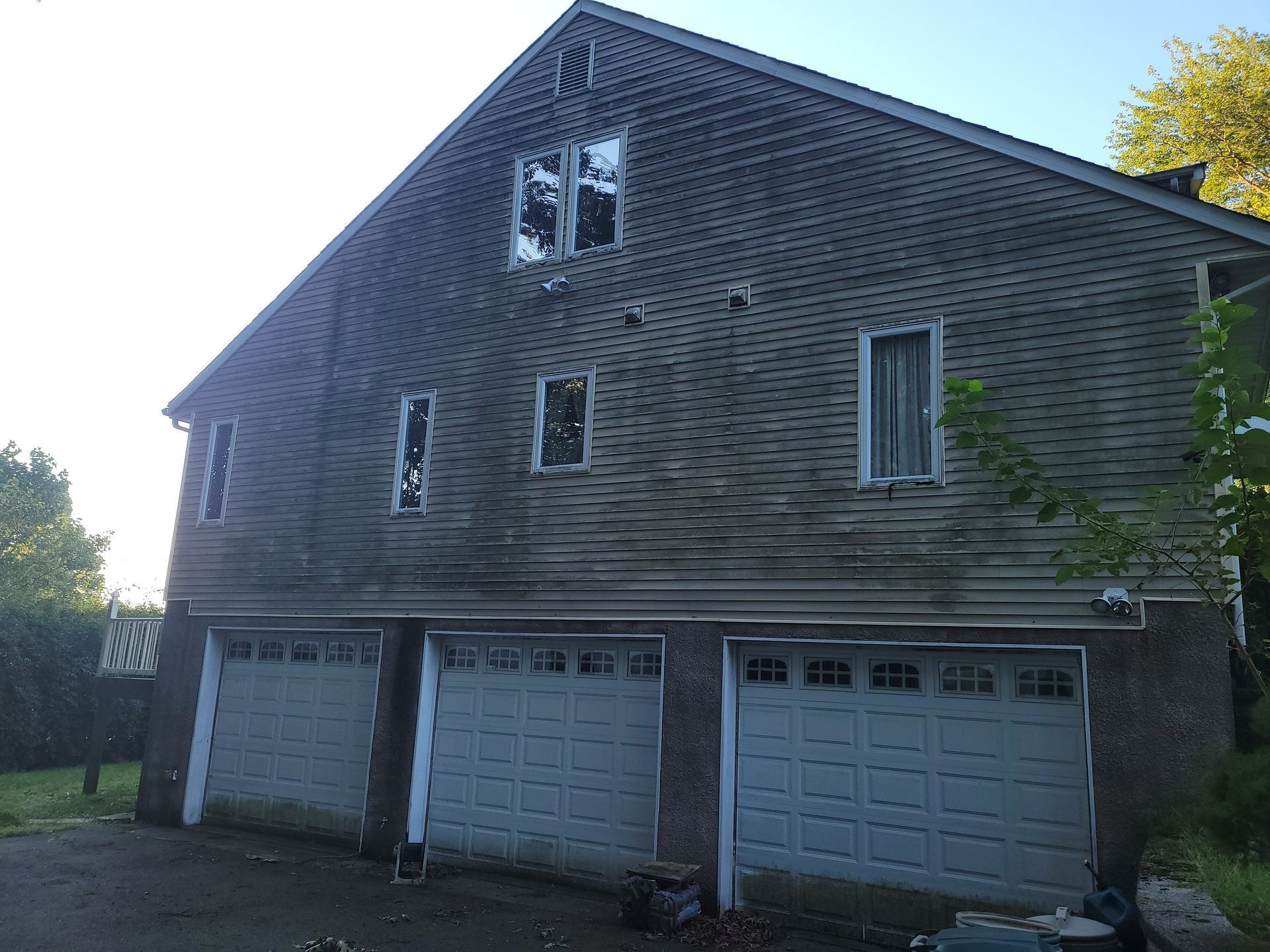 A large house with three garage doors and a broken window