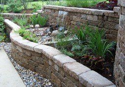 Tiered retaining wall with landscaping & water feature