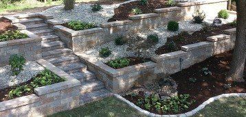 Tiered mosaic retaining wall with steps, landscaping & water feature