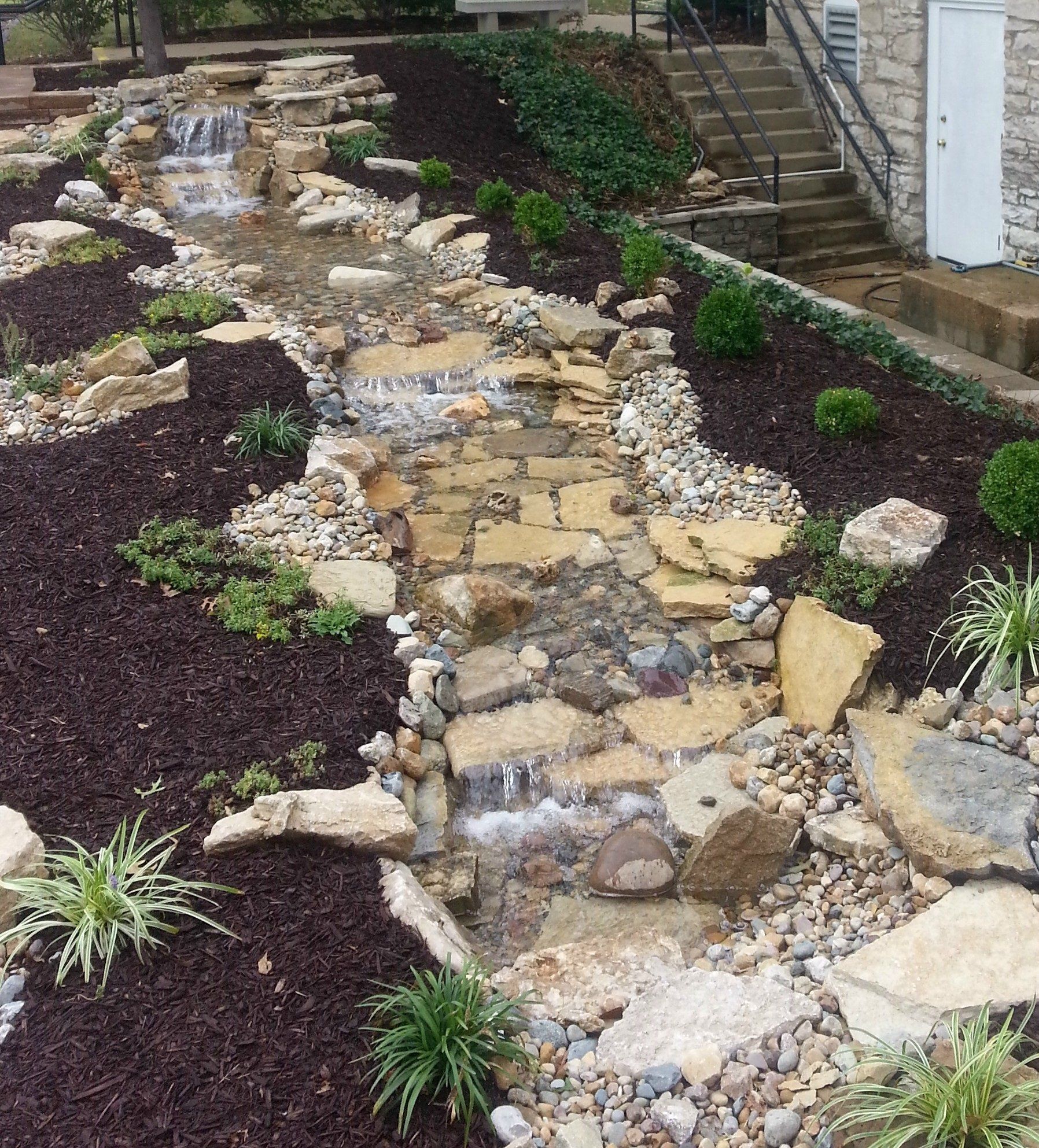 Natural stone wall water feature with gravel accents