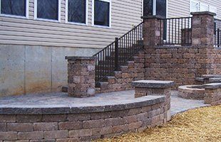 Multi-level paver patio with built-in fire-pit, columns