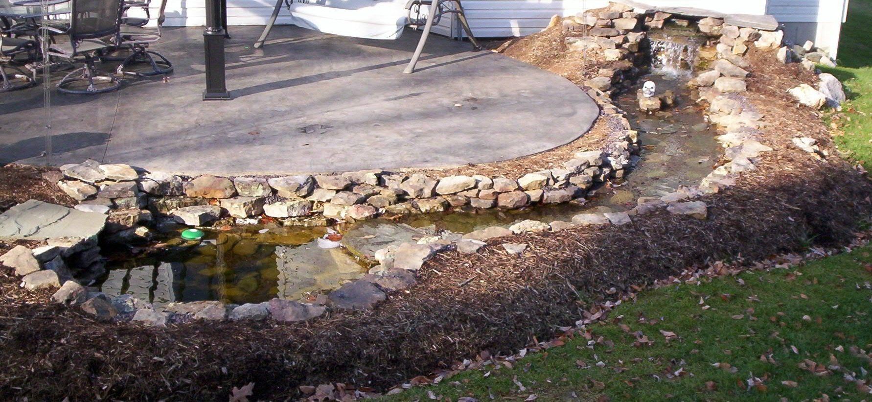 Natural stone wall water feature with gravel accents