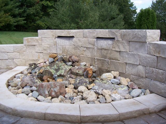 Natural stone wall water feature with gravel accents
