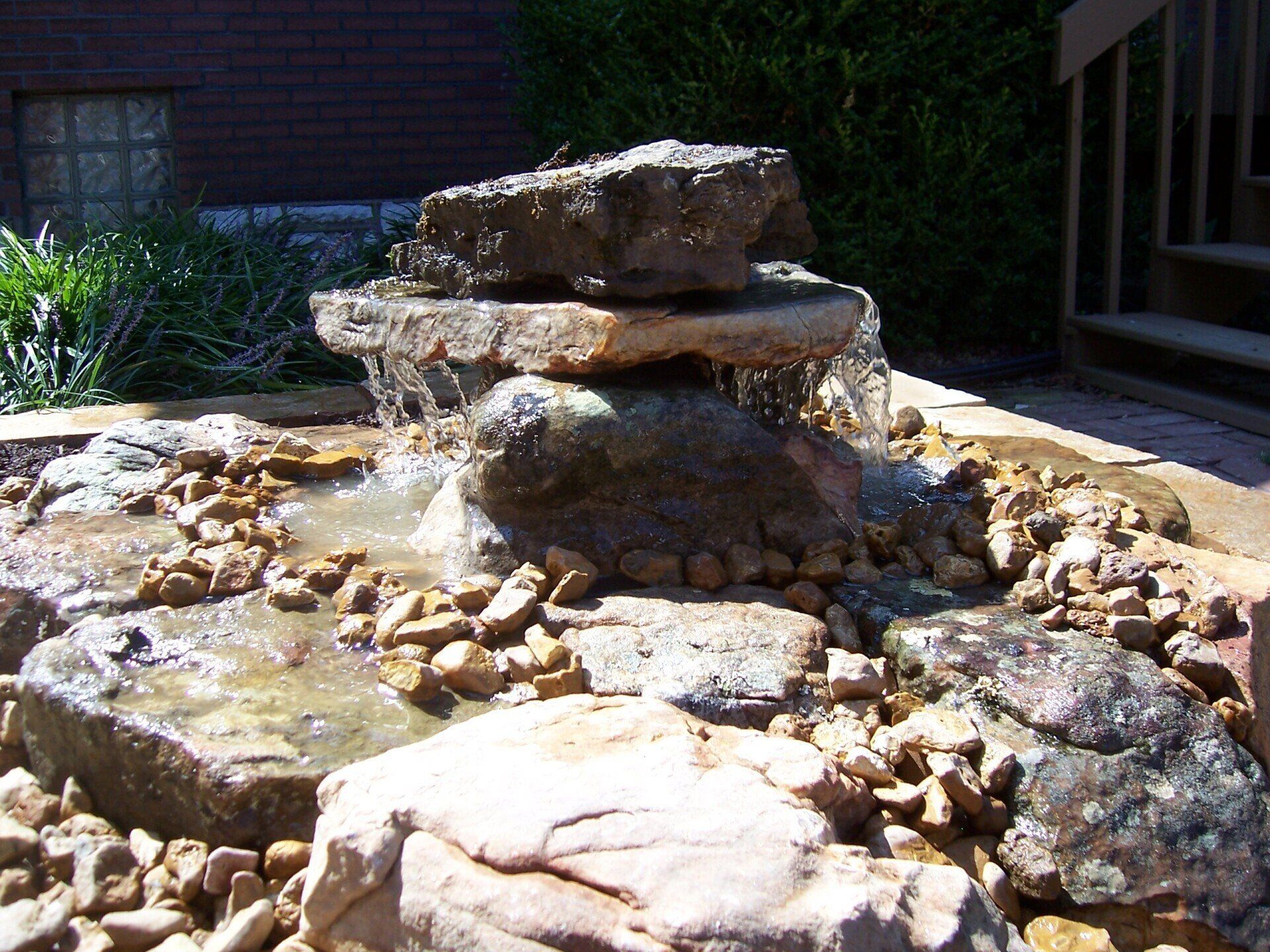 Natural stone wall water feature with gravel accents