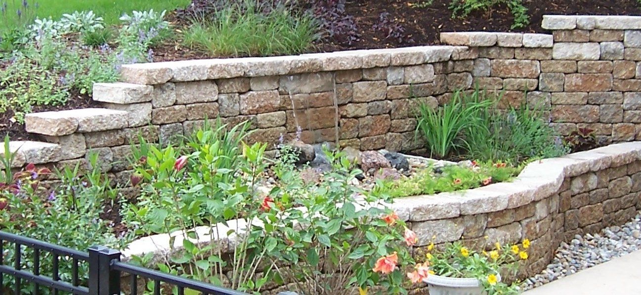 Natural stone wall water feature with gravel accents