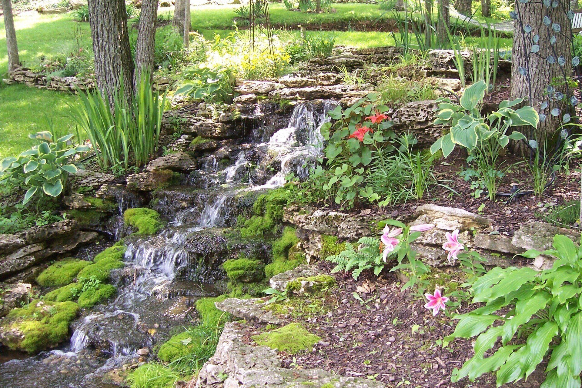 Natural stone wall water feature with gravel accents
