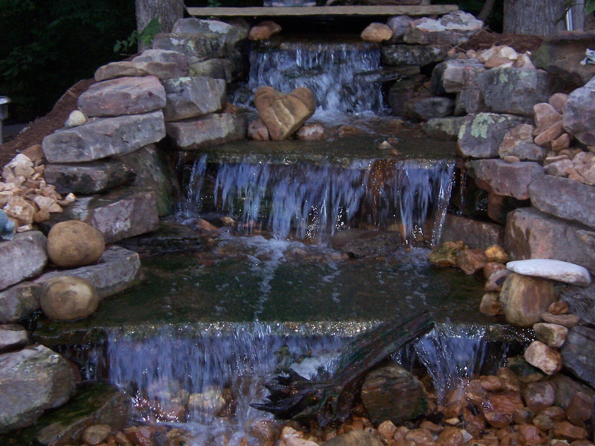 Natural stone wall water feature with gravel accents