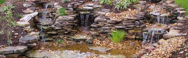 Natural Weathered stone water feature with gravel accents & landscaping