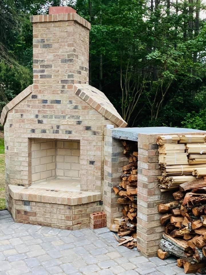 Brick outdoor fireplace with firewood storage.