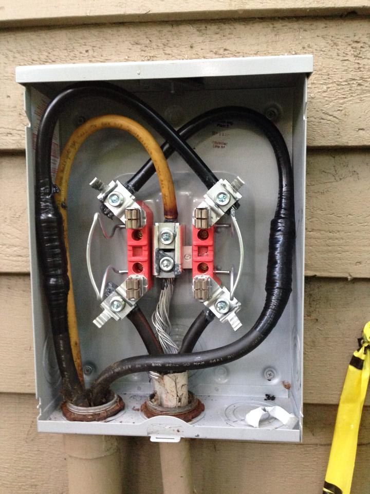Open electrical box with wires connected to terminals. The box is mounted on siding.