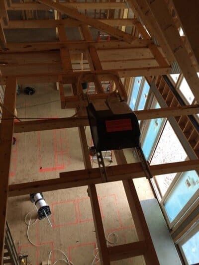 Wooden frame interior construction with a garage door opener installed.