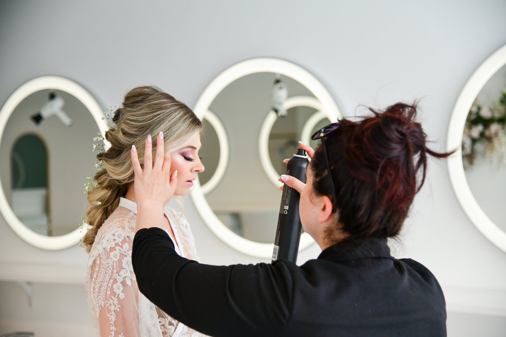 Woman having her hair styled with hairspray in a salon.