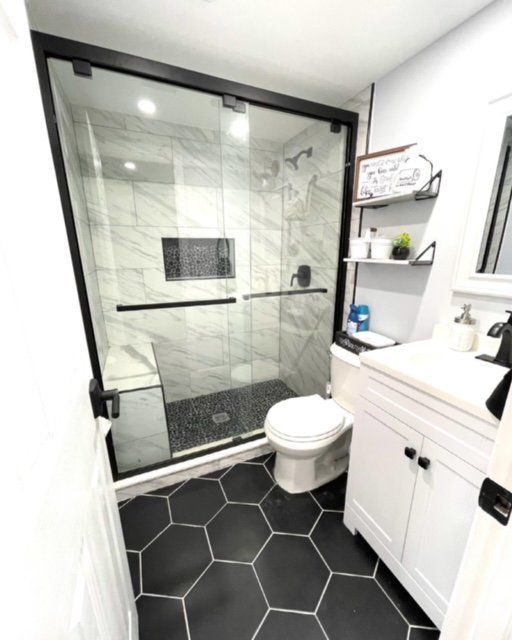 A bathroom with a toilet a sink and a shower