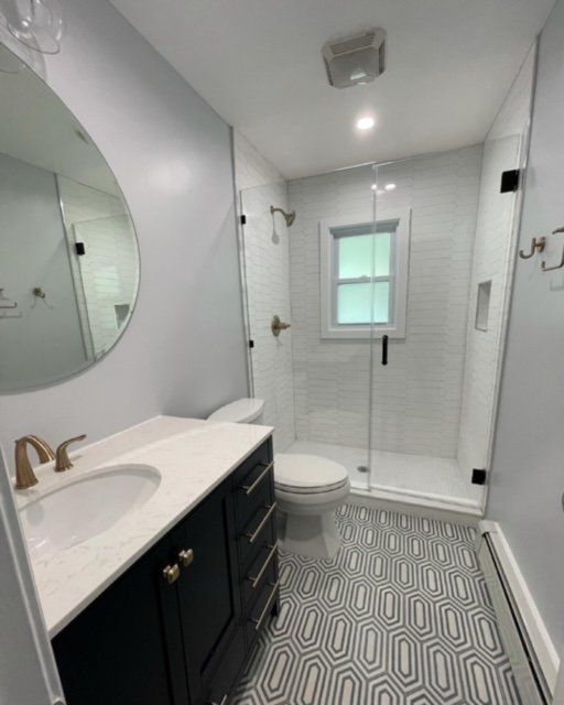 A bathroom with a sink , toilet , shower and mirror