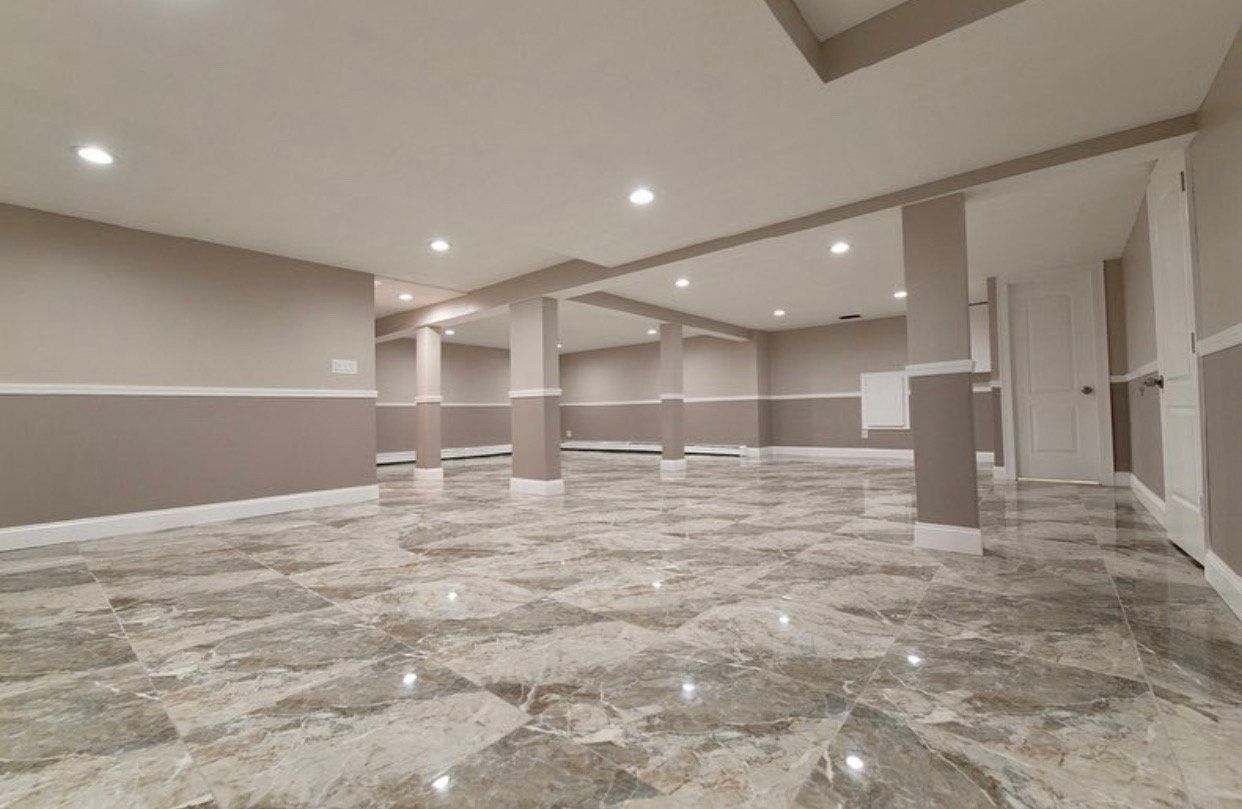 A large empty basement with marble floors and walls.