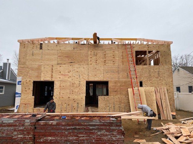 A house is being built with plywood and a ladder.