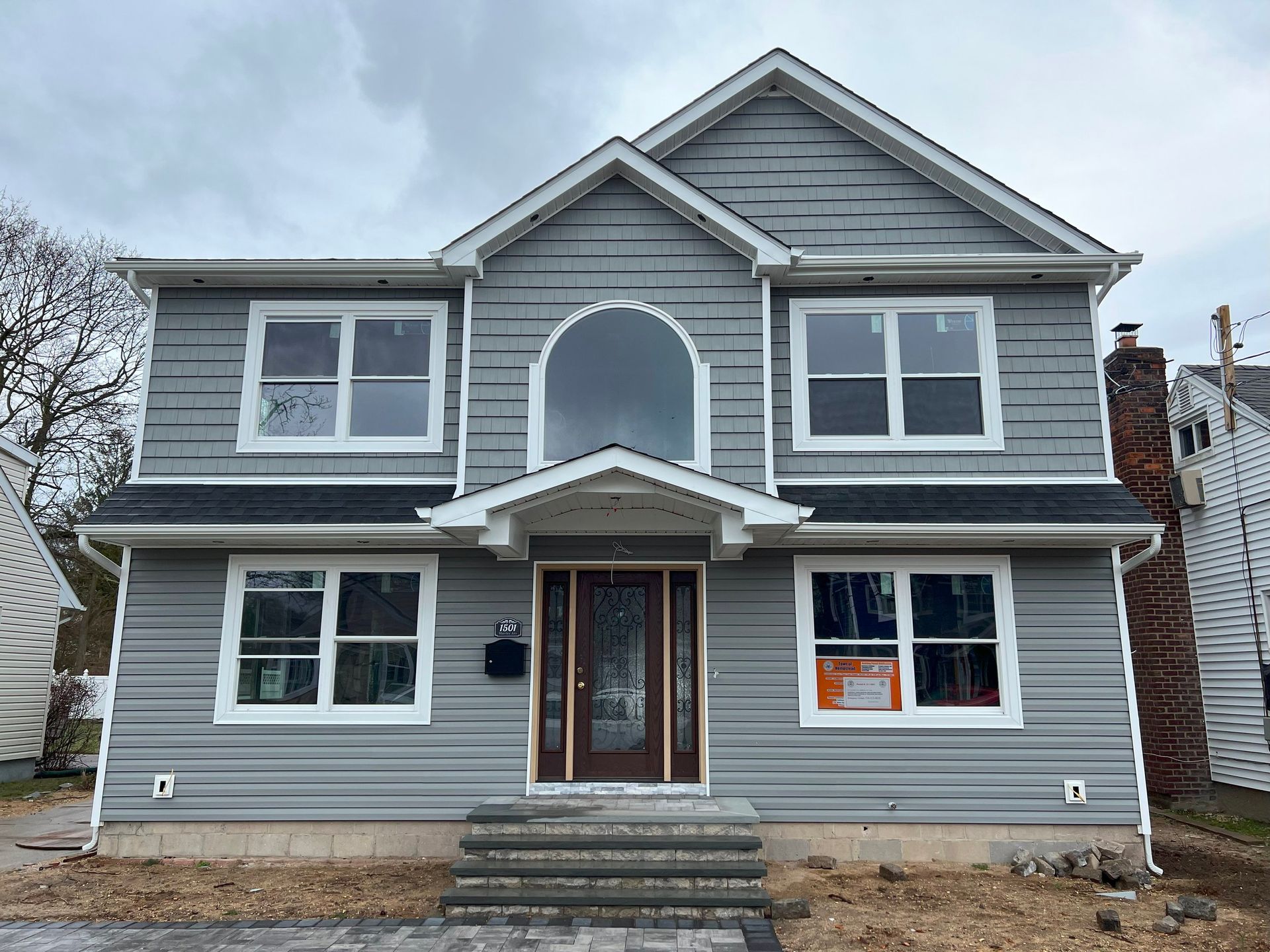 A large gray house with a lot of windows and stairs.