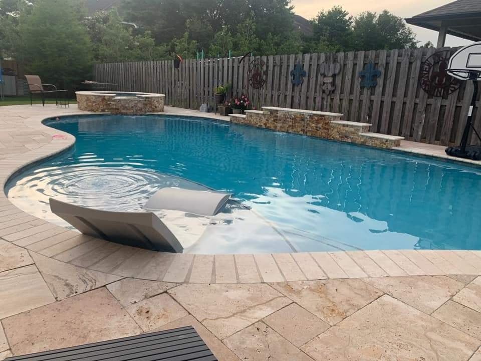 Curved backyard swimming pool with stone deck in LaPlace, LA