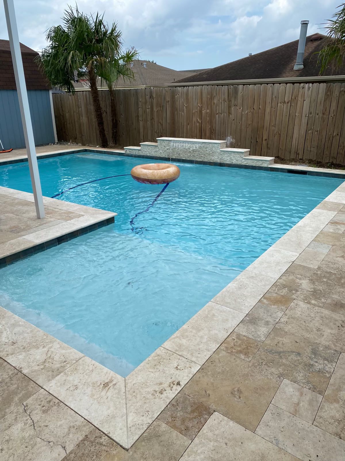 Pool with raised edge and floating ring under covered patio in Belle Chasse, LA