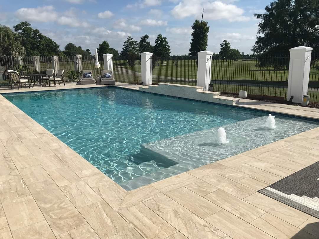 Long rectangular pool with deck jets in Hammond, LA backyard