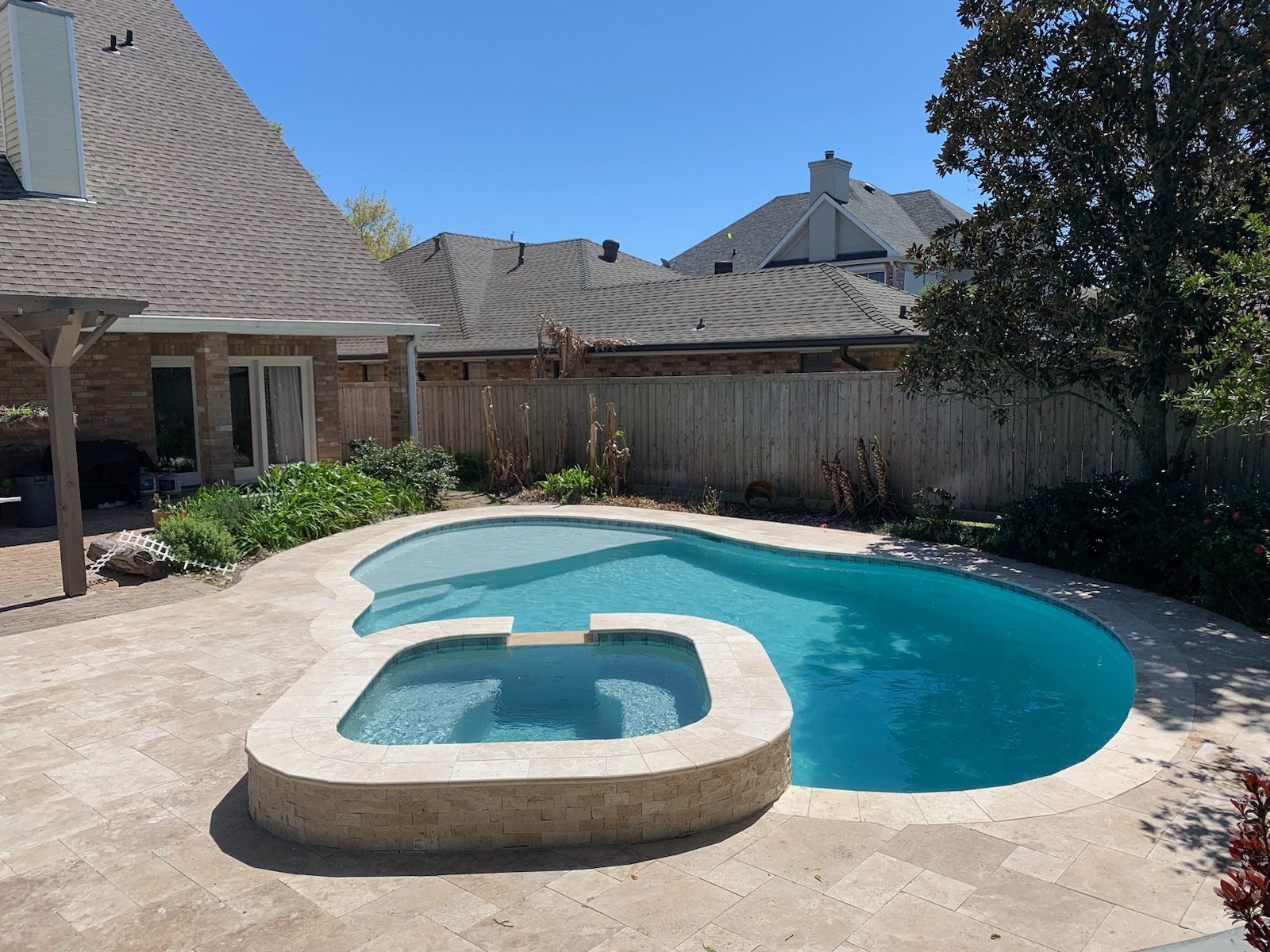 Curved spa and pool combo in backyard of a home in Luling, LA