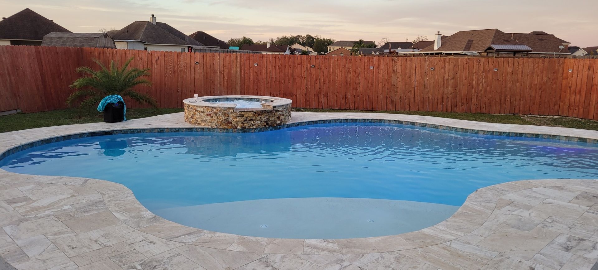 Freeform swimming pool with raised spa and privacy fence in LaPlace, LA