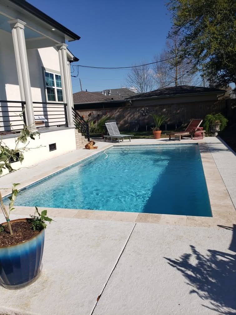 Rectangular pool with travertine tile and lounge area in Reserve, LA