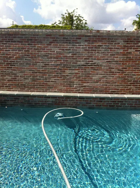 A swimming pool with a brick wall in Mandeville, LA