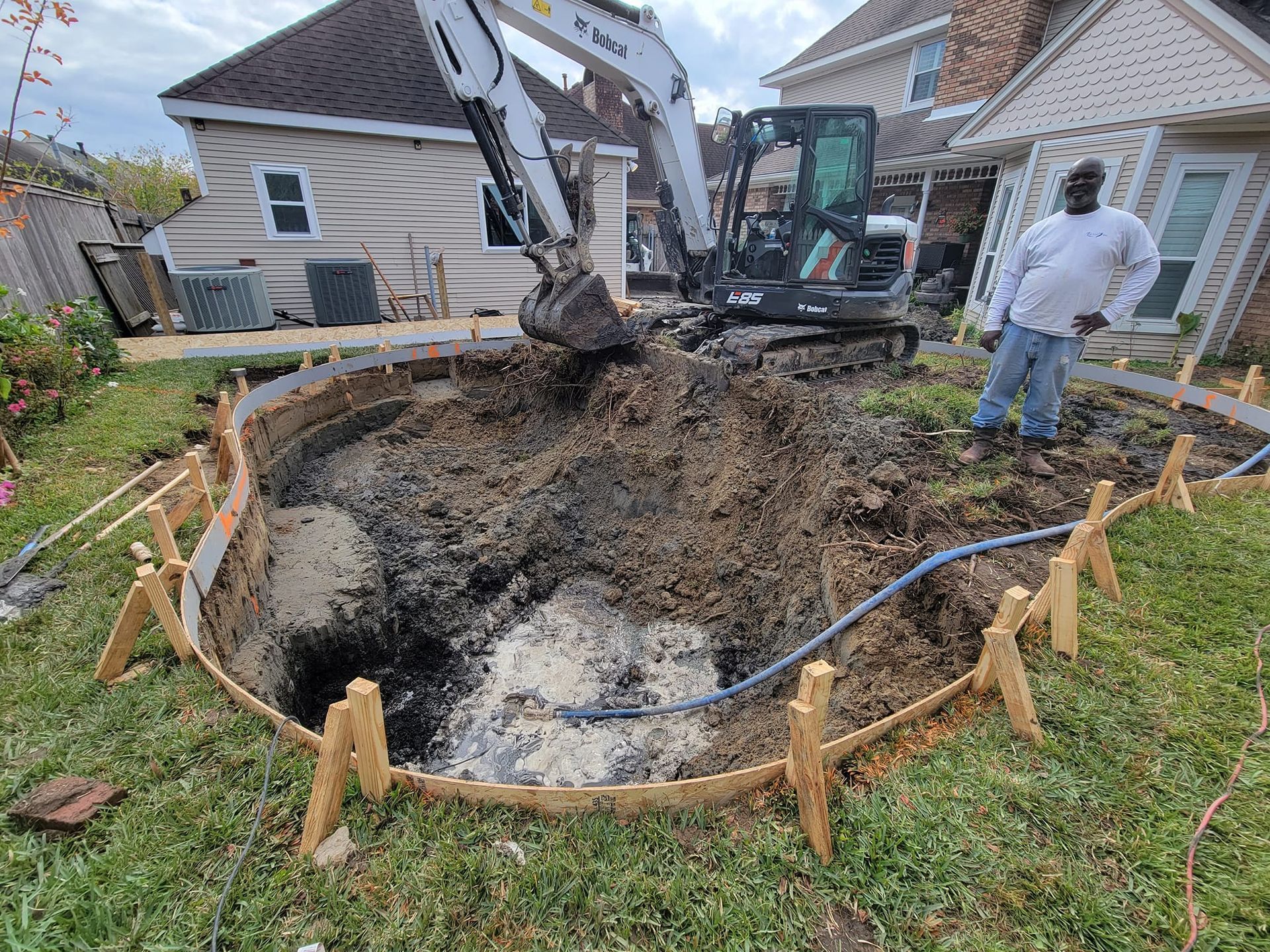 An excavator is digging a hole for custom in-ground pool installation in Prairieville, LA