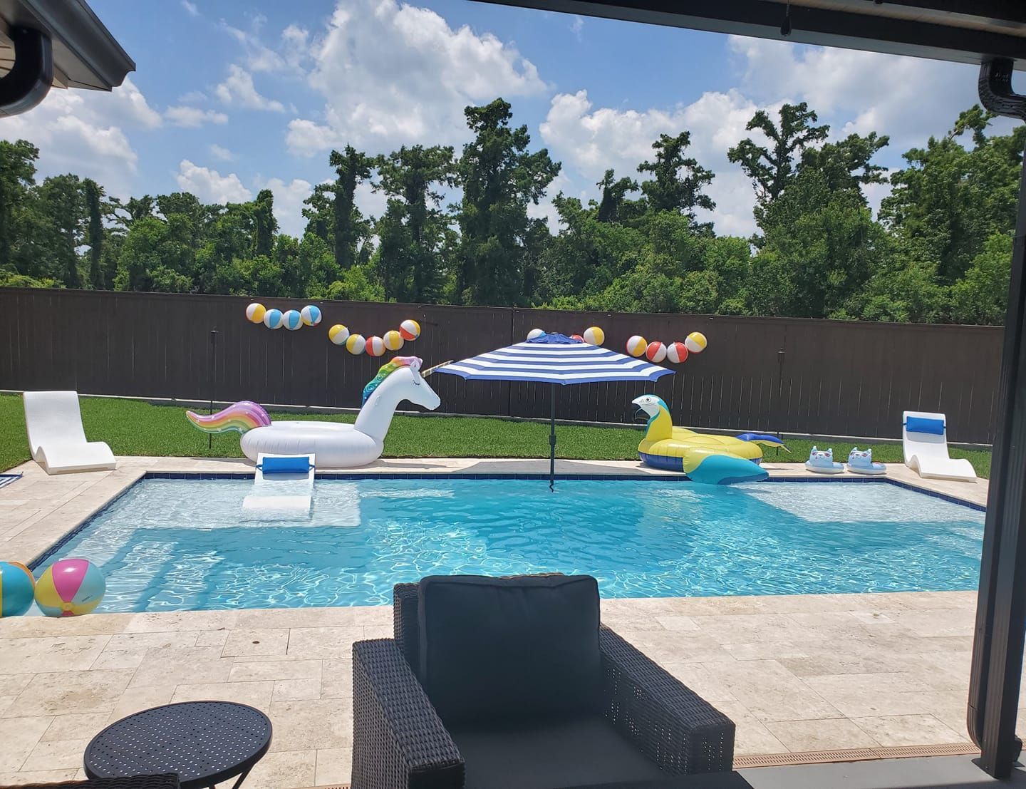 Backyard pool party with unicorn float and patio umbrella in Hammond, LA